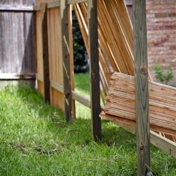 Puidust aiapaneelid on paigaldatud muruplatsile toetudes kaldega konstruktsioonile. Muru on roheline ja aia taustal näha telliskivisein.