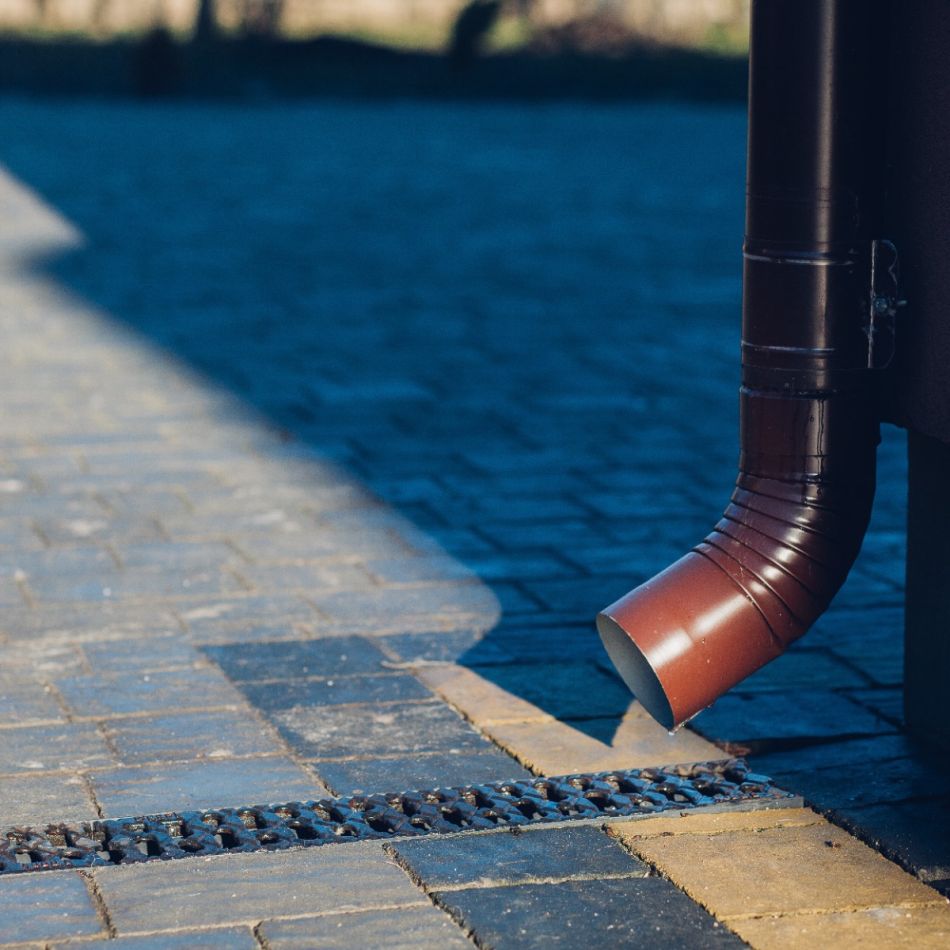 Punakaspruun vihmaveetoru suunab vett hallile sillutatud teele, tagades efektiivse vee äravoolu.