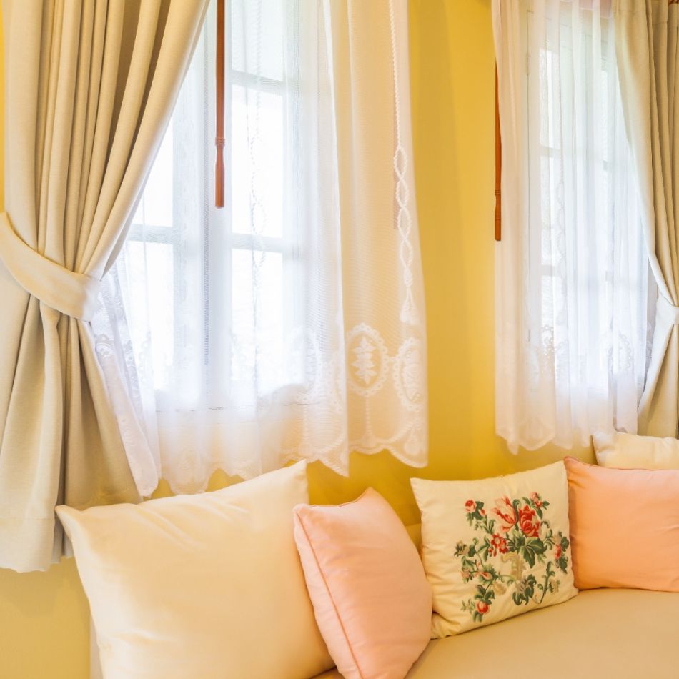 Hele ja õhuline interjöör beežikate ja pastelsete toonidega. Aknal on beežid pimendavad kardinad ja valged tüllkardinad, mis sobivad hästi kokku beežikas diivaniga, millel on pastelsed padjad.