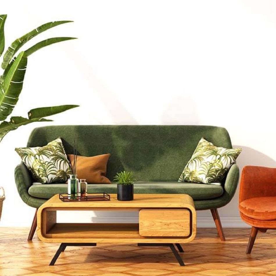 Stiilne elutuba, kus on roheline sametdiivan, mustriliste patjadega, kaasaegse disainiga puidust kohvilaud ja väike oranž tugitool. Taustal on suur roheline taim.