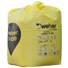 Kollane suur Weber S-100 kuivbetoonikott, kaaluga 1000 kg, etiketil on tooteinfo ja tehnilised andmed.